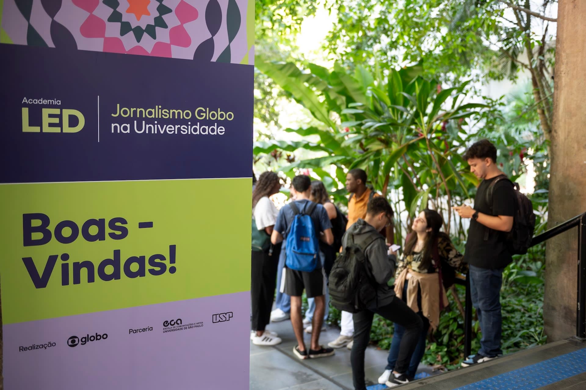 Grupo de convidados em escadaria colorida com tema "Toda beleza de ser carioca"