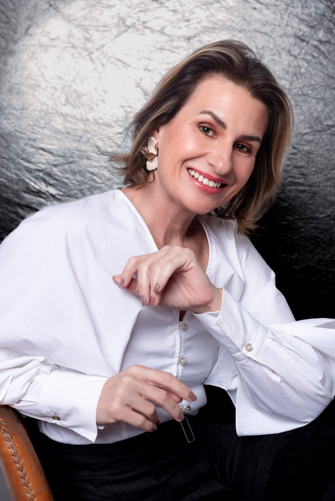 Retrato corporativo de mulher de camisa social sorrindo espontaneamente, leveza e acolhimento, ensaio Aura Estúdio Rio de Janeiro