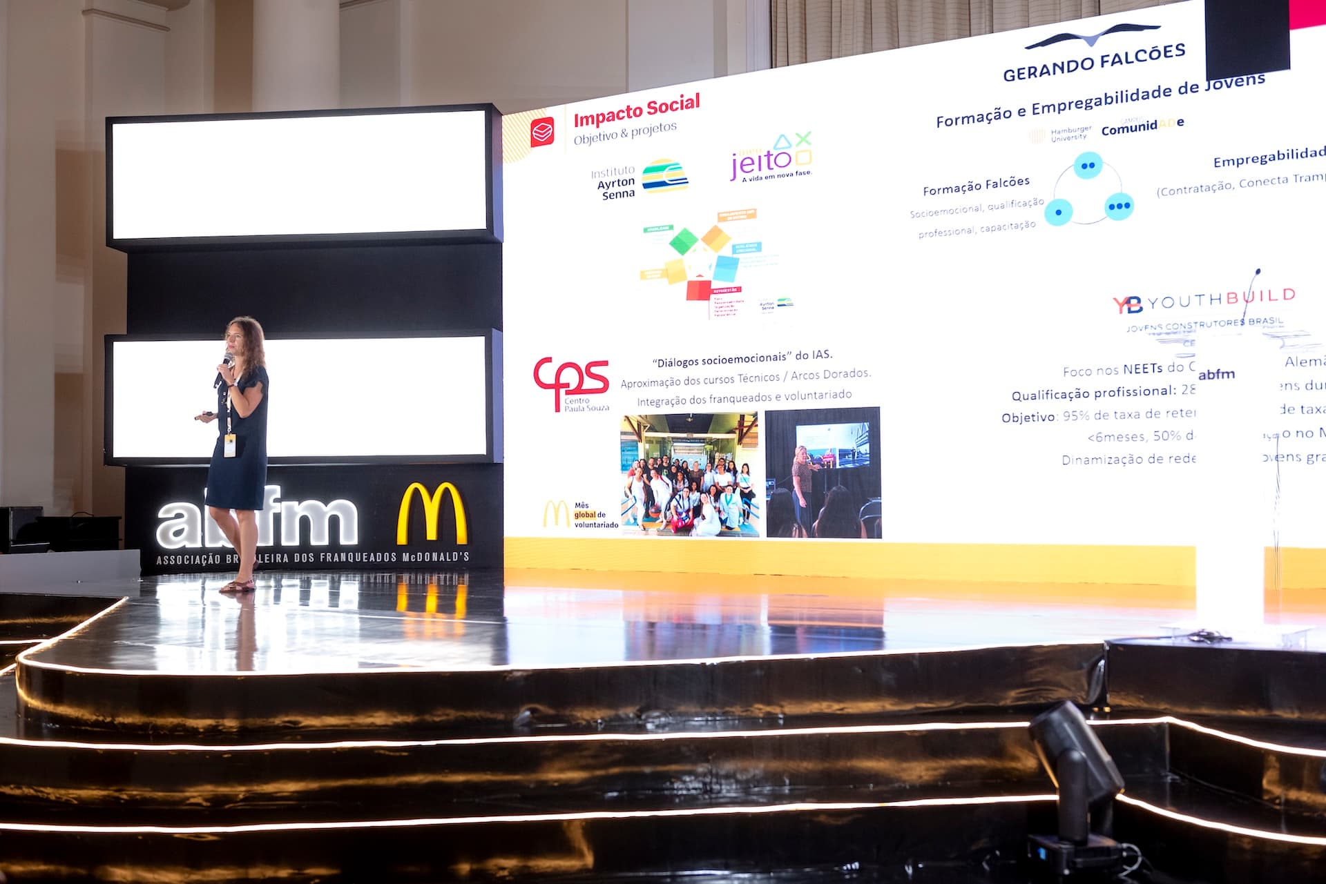 Palestrante no palco apresentando projetos de impacto social e empregabilidade de jovens, convenção McDonald's
