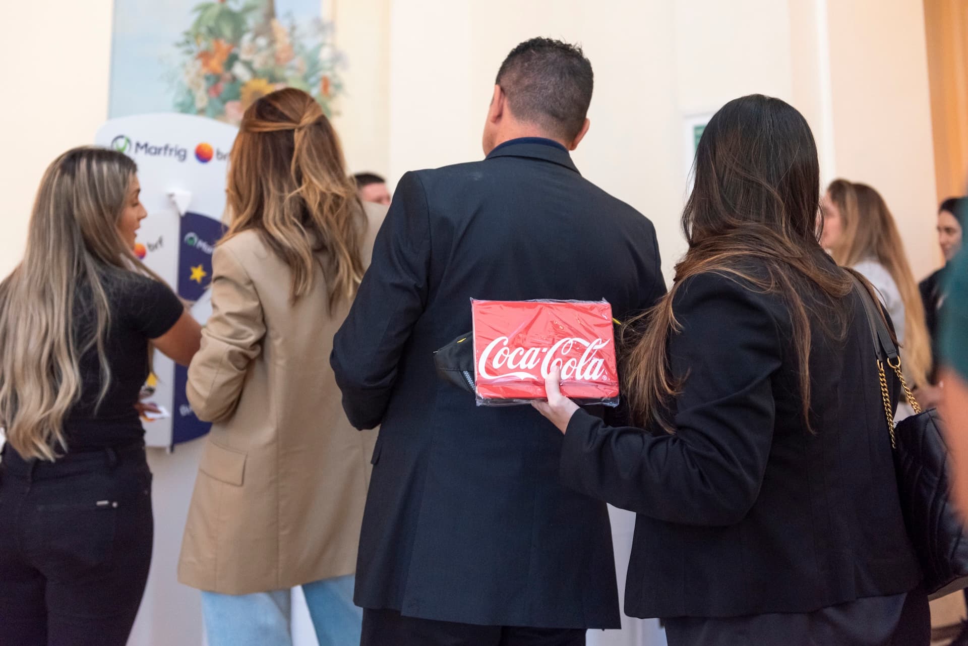 Grupo de costas participando de dinâmica com roleta de prêmios em convenção corporativa